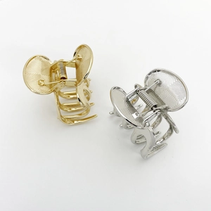 Detail of gold and silver square alloy hair claws showing brushed metal texture and spring