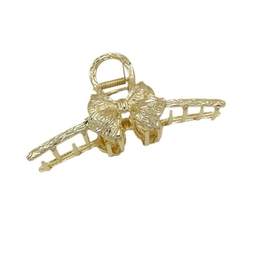 Golden alloy bow hair claw clip with textured metallic finish for thick hair styling