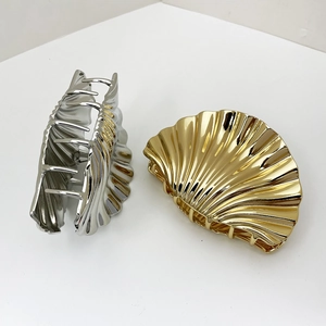 Large metallic shell hair claws in gold and silver finish with textured 3D ridges
