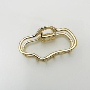 Polished gold metal cloud hair claw clip with irregular wave design and shiny finish