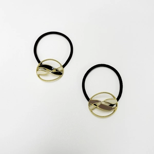 Detail of metal elastic hair ties with black white enamel and gold textured borders