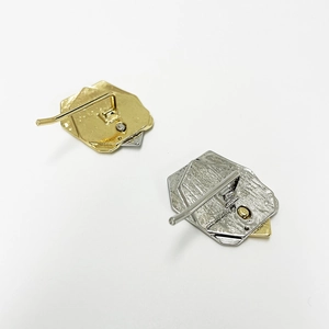 Detailed back view of metal ponytail hooks in gold and silver with hammered textures