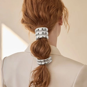 Close-up of polished silver alloy ponytail cuff hair rings on a low ponytail hair style