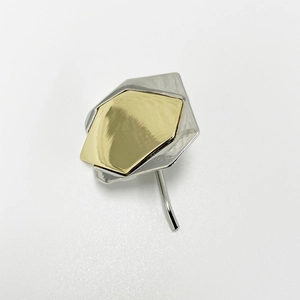 Detail of two-tone geometric metal hair clip with polished gold and silver finish