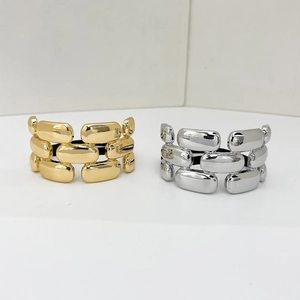 Close-up of high-polish gold and silver alloy chain link hair ties in minimalist style