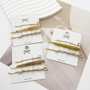 Three-piece hair clip set with marble texture and gold twist designs on white display cards