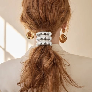 Close-up of a silver polished metal hair cuff on a ponytail for an elegant hairstyle