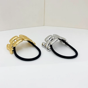 Macro shot of silver and gold metallic chain links on high-elastic black hair ties