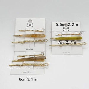 Elegant gold-tone metal hair clip set with resin accents and rhinestone on card