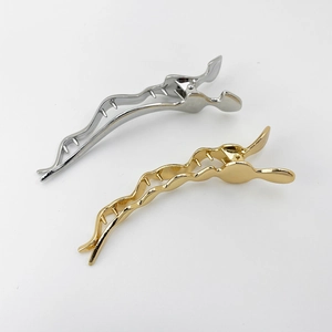 Close-up of gold and silver alloy wavy hair clips with a polished electroplated finish