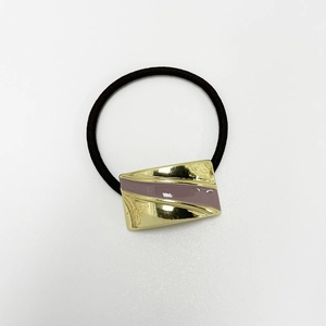 Detailed close-up of golden metal hair tie with purple enamel on black elastic band