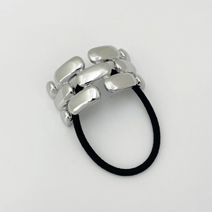 Macro shot of polished silver alloy chain blocks on a black elastic hair tie