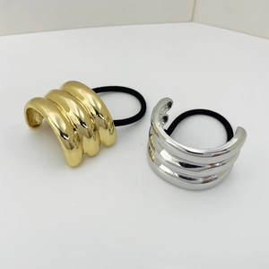 Macro shot of minimalist gold and silver metallic U-shaped hair ties on white background