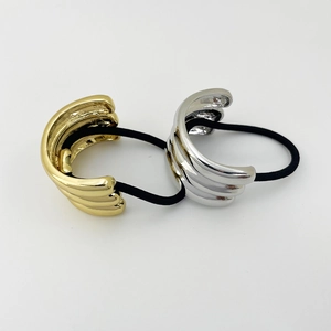Detail of gold and silver C-shaped metal hair ties with elastic black rubber bands