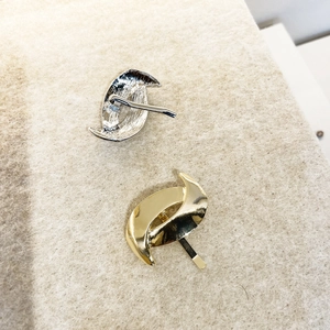 Minimalist metallic gold and silver hair hook clips with sleek curved design on felt