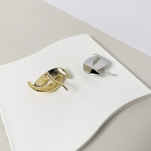 Detailed macro view of gold brushed and silver mirror polished alloy hair hook accessories
