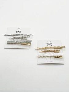 Détail de barrettes à cheveux en perles et résine marbrée en ensembles dorés et argentés