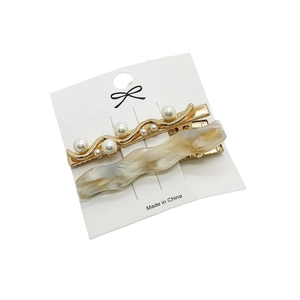Elegant gold pearl and cream marble wave hair clips set on a display card