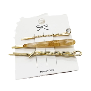 Three-piece gold hair clip set with rhinestone and amber resin on display card