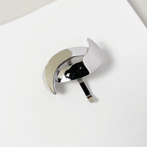 Close-up of polished silver alloy hair hook with minimalist curved geometric design