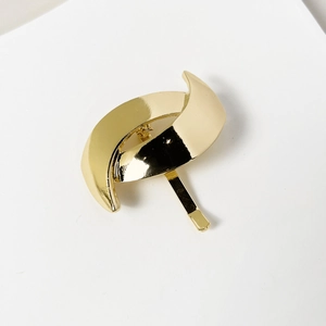 Close-up of golden metal hair hook with smooth polished mirror finish for ponytails