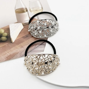 Detail of luxury pearl and rhinestone hair tie with vintage gold and silver metal charms
