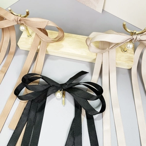 Elegant bow hair clips with long ribbons and pearl pendants in black, khaki, and cream