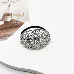 Detailed close-up of a silver hollow hair tie with white pearls and sparkling crystals