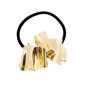 Minimalist gold metal hair tie with irregular wave texture on black elastic band