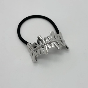 Close-up of high-elastic black hair tie with polished silver irregular geometric metal piece