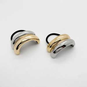 Details von minimalistischen gold- und silbernen U-förmigen Metallakzenten auf Haargummis