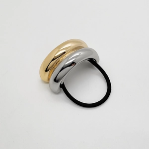Makro-Detail des minimalistischen zweifarbigen U-förmigen Metall-Haargummis in Gold