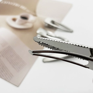 Macro detail of the bright silver metal hair clip with secure serrated teeth design