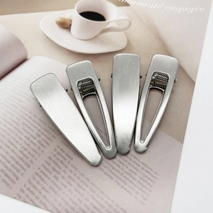 Set of 4 brushed metal hair clips featuring teardrop and solid designs in silver finish