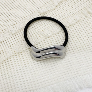 Close-up of black elastic hair tie with polished silver wave-shaped alloy buckles