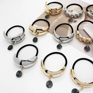 U-shaped gold and silver alloy hair ties with stone pendants and glossy metallic finish