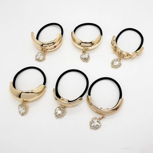Set of six gold alloy ponytail holders with heart rhinestone pendants on black elastic bands