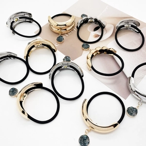 U-shaped alloy hair ties with stone pendants in gold and silver finish on magazines