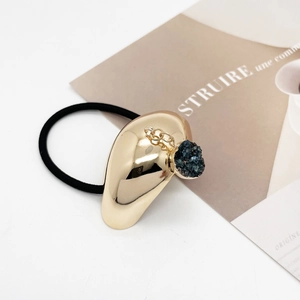 Detail of U-shape gold alloy hair tie with blue crystal pendant on elastic rope