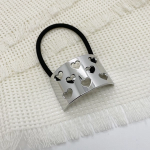 Detail of silver heart cutout alloy buckle on black elastic ponytail holder