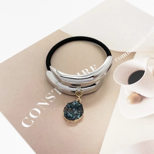 Detailed macro view of U-shaped silver alloy hair tie with a blue-green crystal stone charm