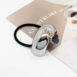 Close-up of sleek ponytail holder with U-shaped alloy扣, elastic band, and blue stone charm