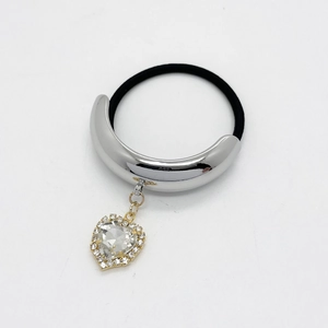 Silver ponytail cuff with crystal heart charm and elastic band on white background