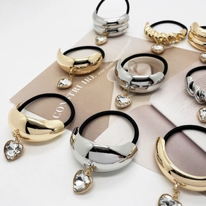 Minimalist U-shaped hair ties with metallic accents and heart-shaped crystal pendants