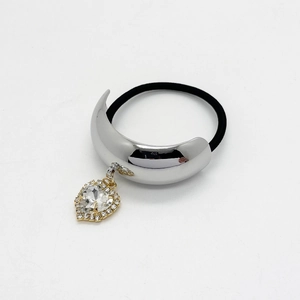 Close-up of a black elastic hair tie with silver U-shape buckle and crystal heart pendant