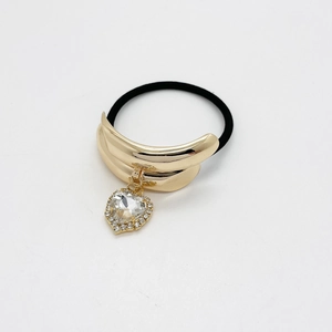 Detail of golden heart pendant with crystals on black elastic ponytail holder