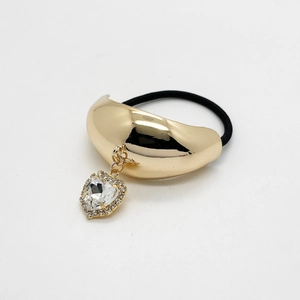 Detail view of a gold alloy U-shape hair ring with heart crystal and rhinestones