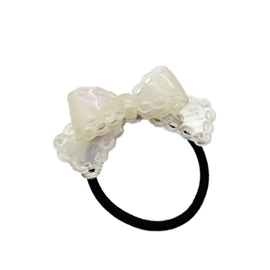 Elegant acetate bow hair tie with pearl-like texture and delicate scalloped hollow edges