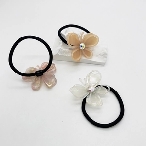 Three elegant butterfly hair ties in cream, pink, and white with sparkling crystals