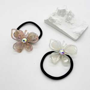 Close-up of butterfly hair ties in pink marble and pearlescent white acetate resin